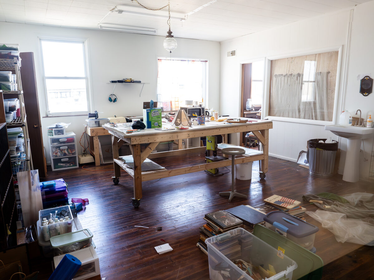 A painter's working bench mid-project — sink, side window, the hum of an actual practice.